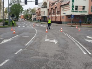 Policjant zabezpiecza przejazd rowerzystów