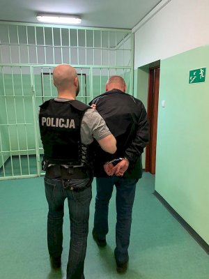 Policjant prowadzi zatrzymanego